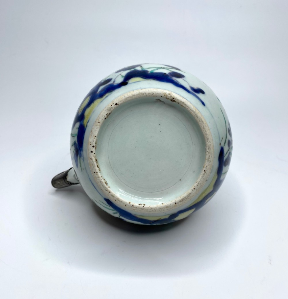 An Edo-period Japanese Imari porcelain sake ewer featuring polychrome floral enamel patterns, an overhead handle, and metal mounts. View VII