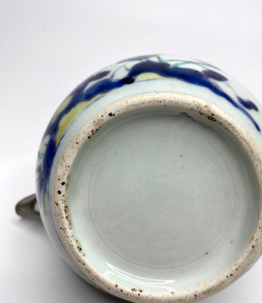 An Edo-period Japanese Imari porcelain sake ewer featuring polychrome floral enamel patterns, an overhead handle, and metal mounts. View VIII