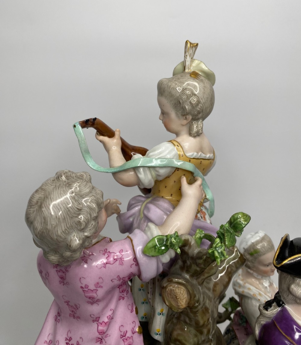 A 19th-century Meissen polychrome porcelain figural group depicting musicians dressed in 18th-century attire gathered around a central column. View VII
