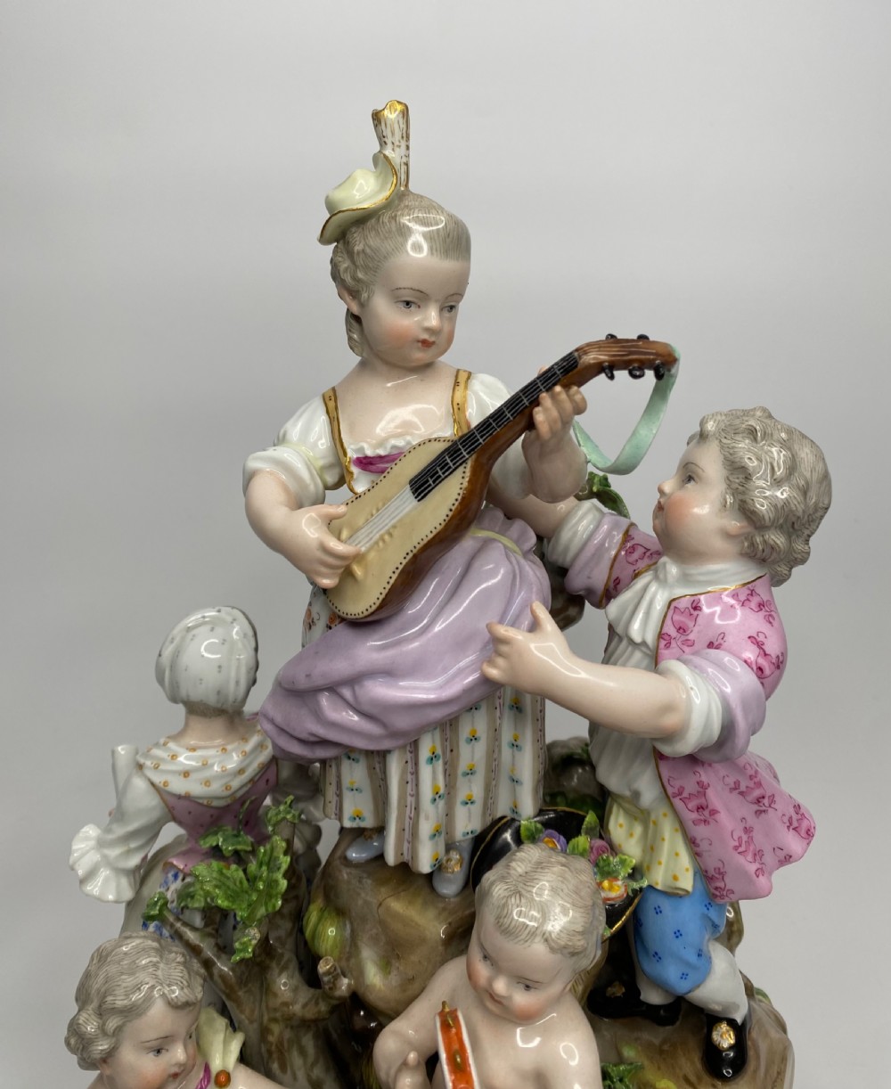 A 19th-century Meissen polychrome porcelain figural group depicting musicians dressed in 18th-century attire gathered around a central column. View IX