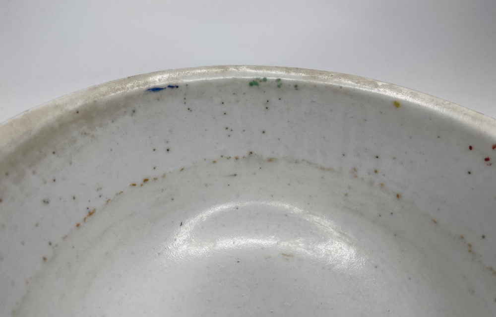 A Chinese Swatow porcelain bowl decorated with red, green, and yellow floral motifs and roundels on an off-white background. View VIII