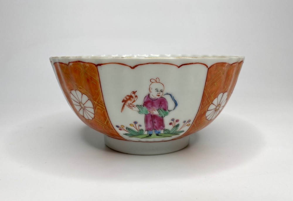 A fluted 18th-century Chinese porcelain bowl decorated in London with alternating panels of orange diaper work and hand-painted figures.