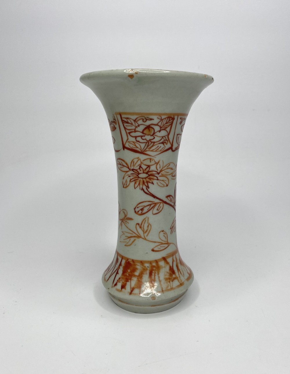 An 18th-century Japanese Arita porcelain beaker vase featuring flared rims and hand-painted iron red floral motifs over a white glaze.