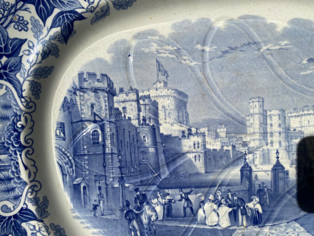 An oval blue and white earthenware meat platter featuring an underglaze transferware illustration of Windsor Castle framed by an ivy leaf border. View III