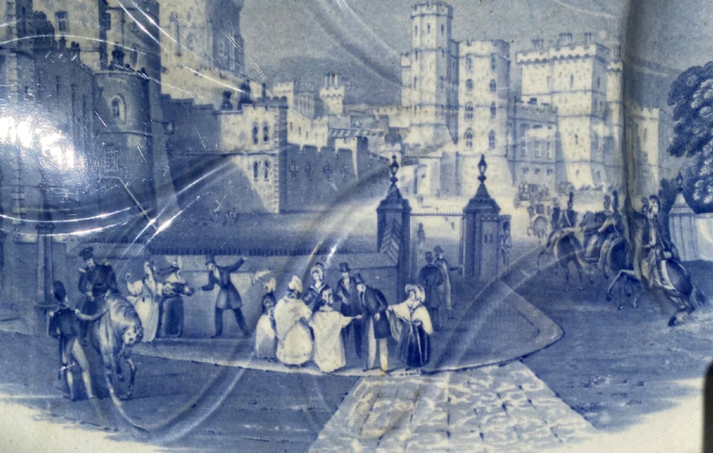 An oval blue and white earthenware meat platter featuring an underglaze transferware illustration of Windsor Castle framed by an ivy leaf border. View V