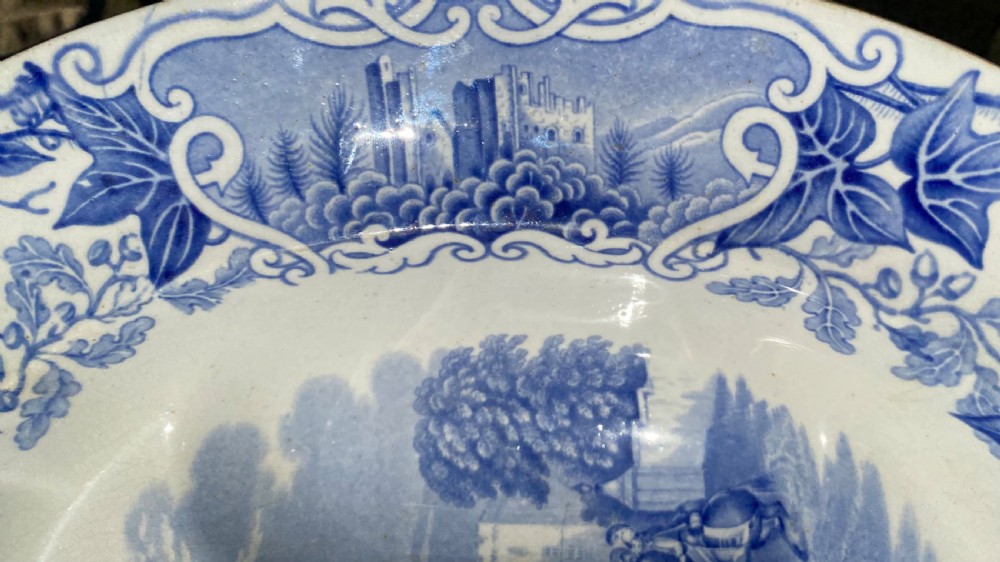 An oval blue and white earthenware meat platter featuring an underglaze transferware illustration of Windsor Castle framed by an ivy leaf border. View VI