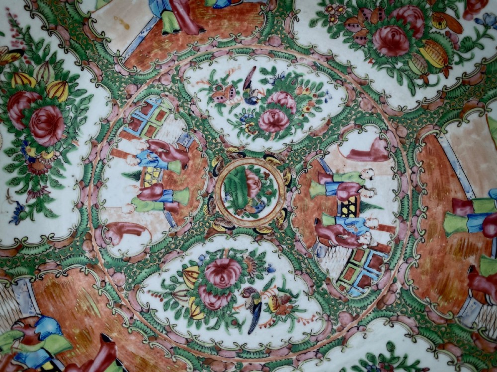 A circular Cantonese porcelain punch bowl decorated internally with hand-painted polychrome panels showing human figures, flowers, and birds framed by green and pink borders. View XVII
