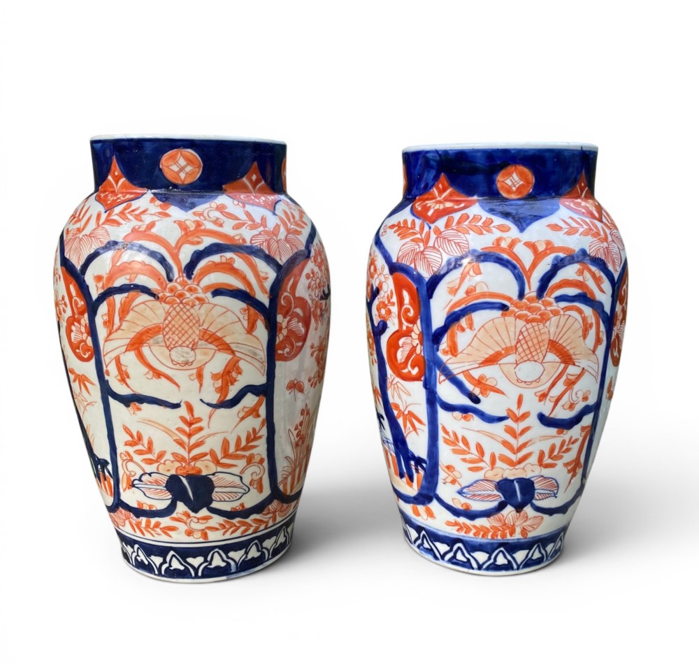 A pair of Japanese Imari porcelain baluster-shaped vases decorated with hand-painted floral patterns in cobalt blue and iron-red enamel on a white ground. View II