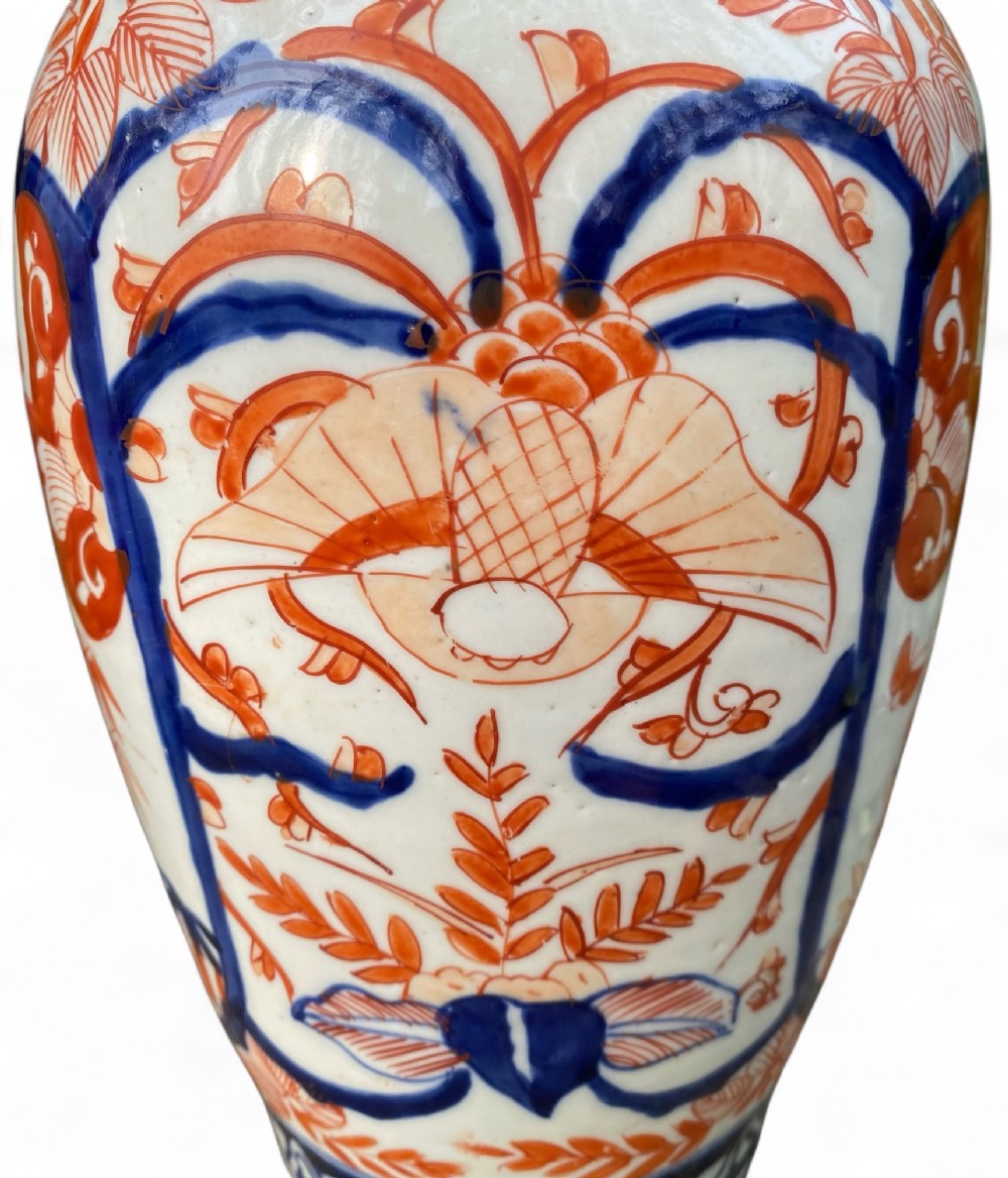 A pair of Japanese Imari porcelain baluster-shaped vases decorated with hand-painted floral patterns in cobalt blue and iron-red enamel on a white ground. View IX