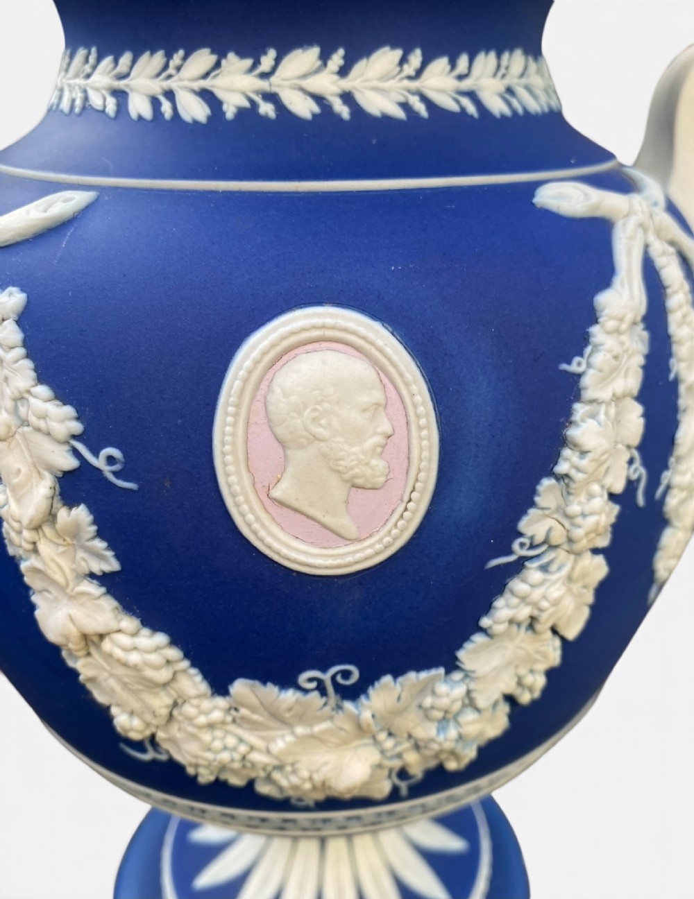 A cobalt blue jasperware pot pourri urn on a matching cylindrical pedestal, featuring white raised relief swags, classical medallions, scroll handles, and a pierced lid. View X