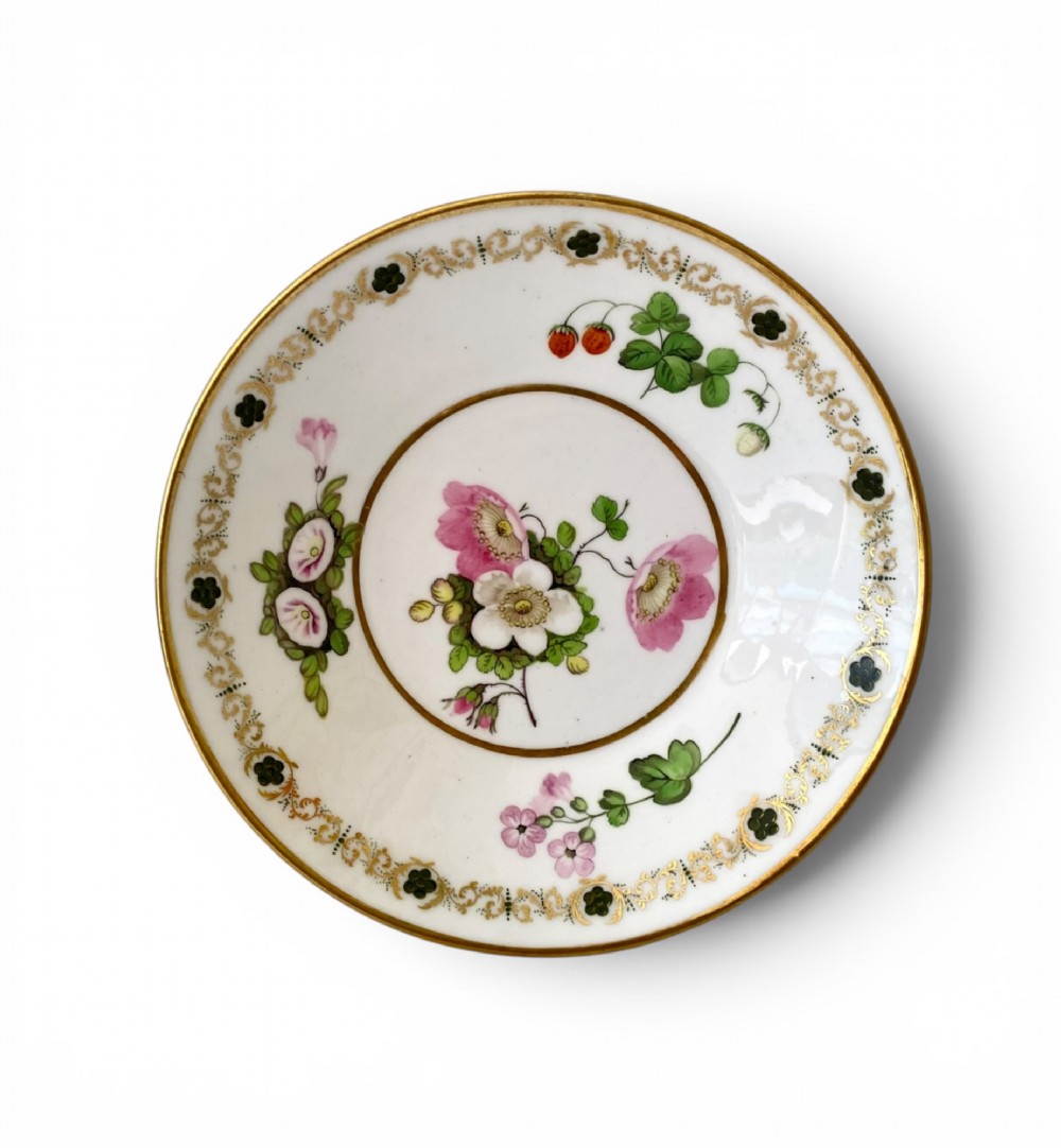 A Regency era white porcelain cup and saucer set decorated with hand-painted pink and white floral motifs and gilded rims. View IX