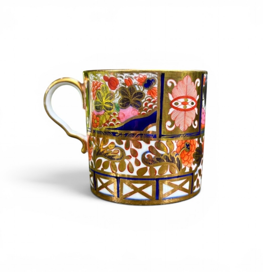 A straight-sided Georgian porcelain coffee can decorated in a Japanese-inspired Imari pattern with cobalt blue, terracotta red, and intricate gold gilding.