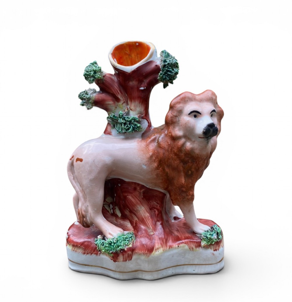 A pair of antique Victorian Staffordshire ceramic spill vases in the form of standing lions beside hollow tree trunks. View II