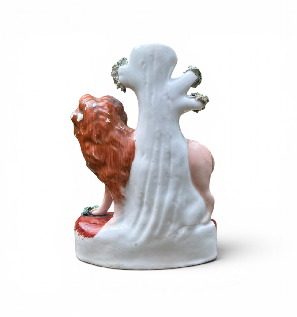 A pair of antique Victorian Staffordshire ceramic spill vases in the form of standing lions beside hollow tree trunks. View V