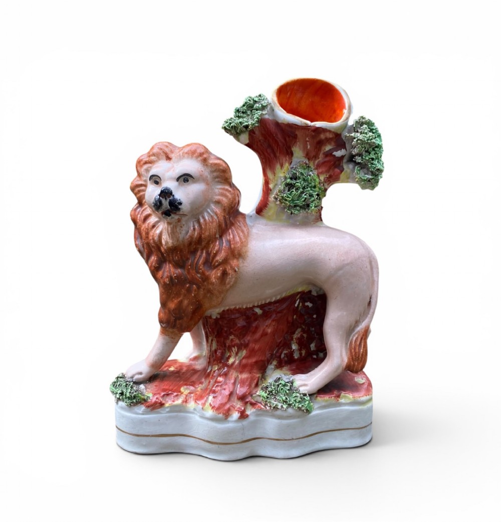 A pair of antique Victorian Staffordshire ceramic spill vases in the form of standing lions beside hollow tree trunks. View VIII