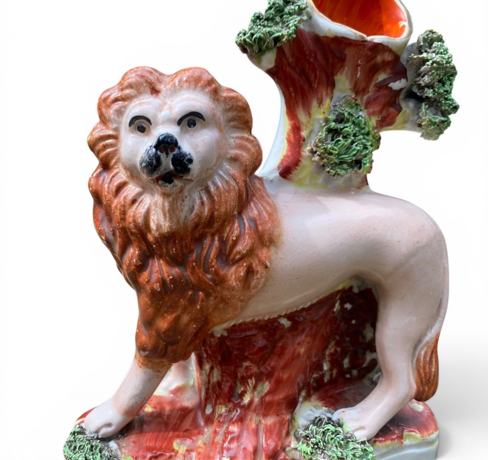A pair of antique Victorian Staffordshire ceramic spill vases in the form of standing lions beside hollow tree trunks. View IX