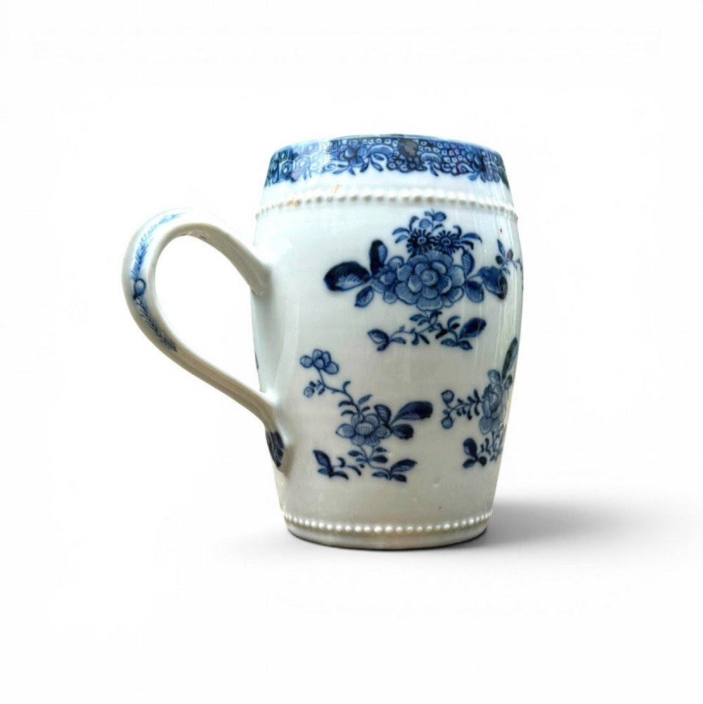 A barrel-shaped Chinese export porcelain mug decorated with a blue painted flower basket motif and raised beaded rims. View V
