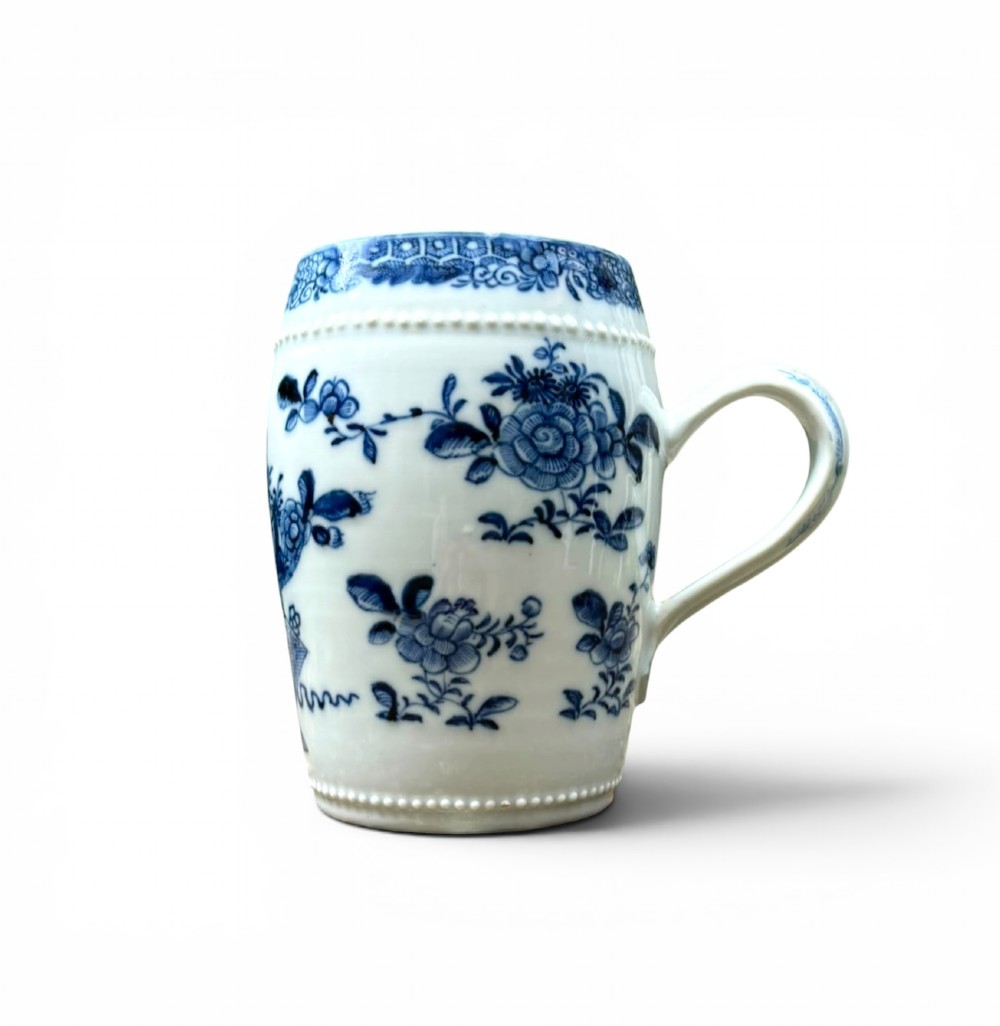 A barrel-shaped Chinese export porcelain mug decorated with a blue painted flower basket motif and raised beaded rims. View VII