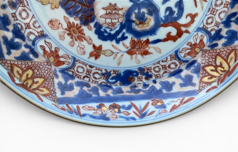 An 18th-century Chinese Imari porcelain dish decorated with underglaze cobalt blue foliage, iron-red enamel florals, and geometric diaper border patterns. View II