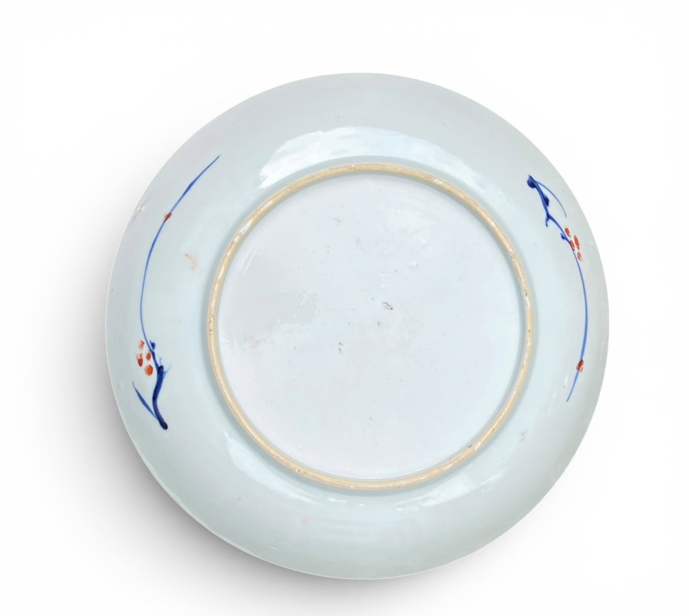 An 18th-century Chinese Imari porcelain dish decorated with underglaze cobalt blue foliage, iron-red enamel florals, and geometric diaper border patterns. View IV