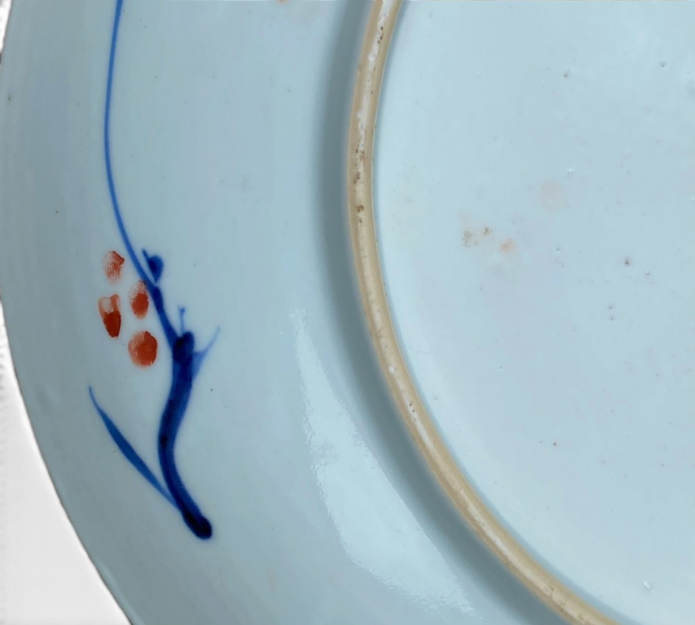 An 18th-century Chinese Imari porcelain dish decorated with underglaze cobalt blue foliage, iron-red enamel florals, and geometric diaper border patterns. View V