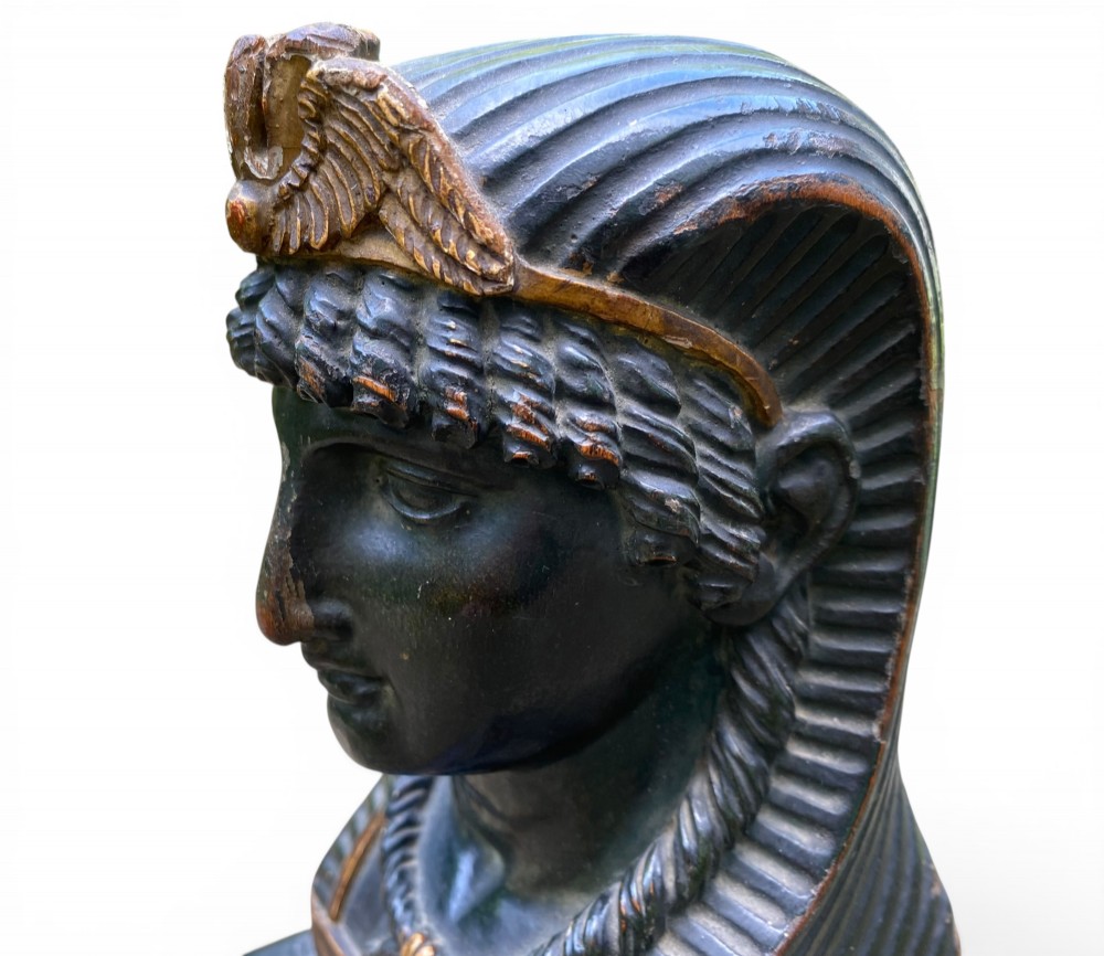A facing pair of carved dark wood sphinx busts with gilt highlights mounted on rectangular black marble bases. View XIII