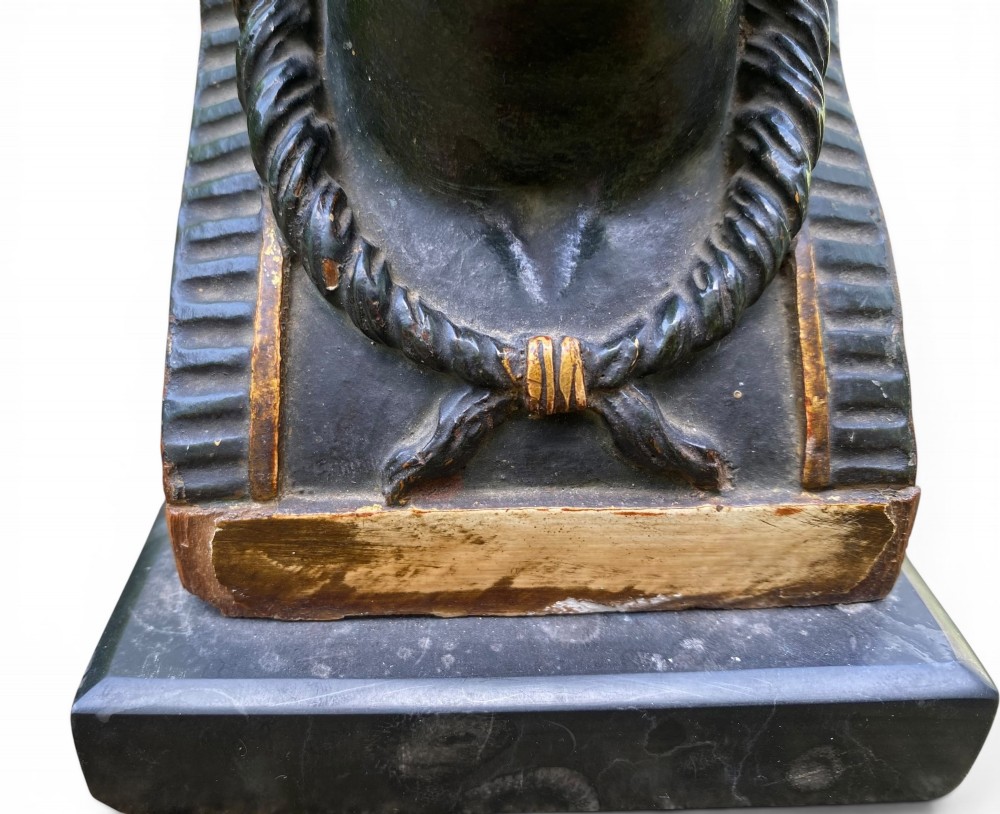 A facing pair of carved dark wood sphinx busts with gilt highlights mounted on rectangular black marble bases. View XIV