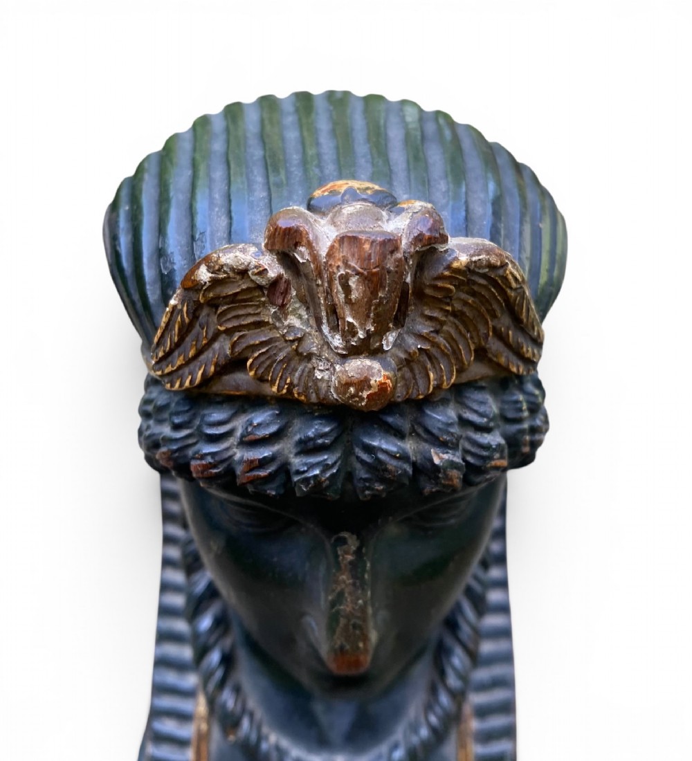 A facing pair of carved dark wood sphinx busts with gilt highlights mounted on rectangular black marble bases. View XV