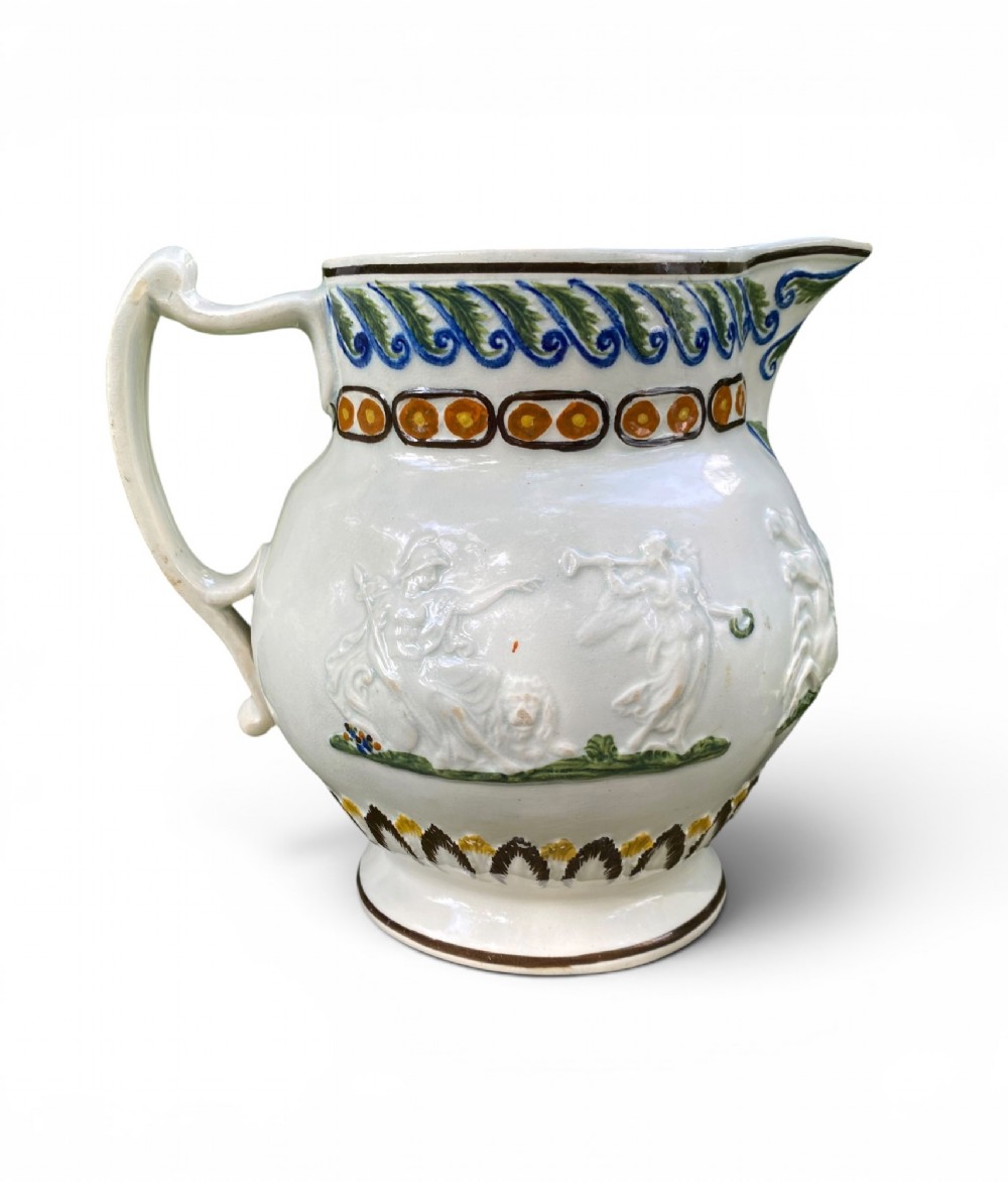 A late 18th-century relief-moulded Prattware ceramic jug featuring polychrome oxide highlights depicting naval battle motifs against an off-white background. View II