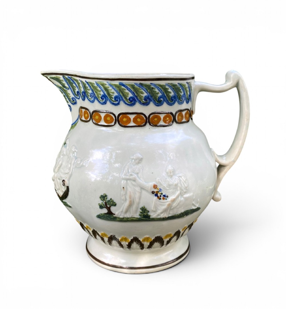 A late 18th-century relief-moulded Prattware ceramic jug featuring polychrome oxide highlights depicting naval battle motifs against an off-white background. View III