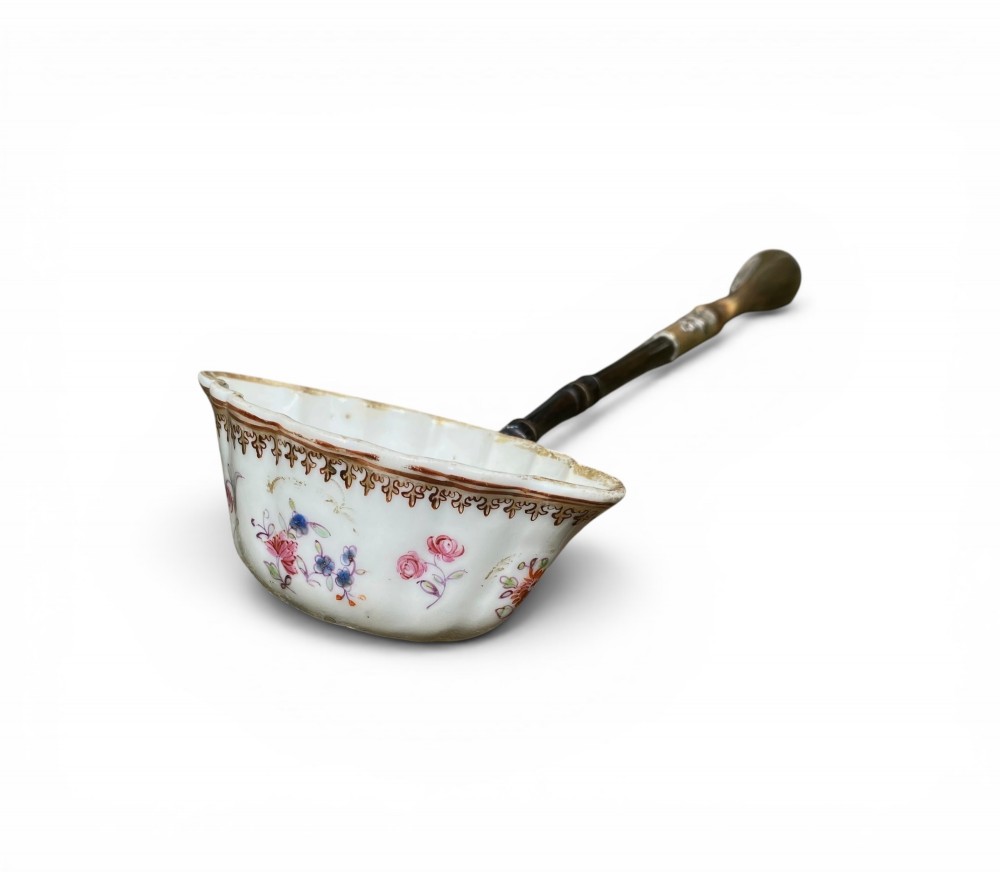 An 18th-century Chinese export famille rose porcelain ladle featuring a lobed white bowl painted with pink floral motifs and fitted with a dark turned handle.