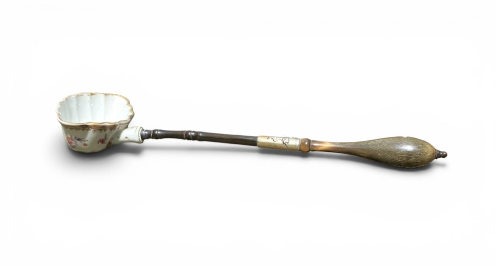 An 18th-century Chinese export famille rose porcelain ladle featuring a lobed white bowl painted with pink floral motifs and fitted with a dark turned handle. View II