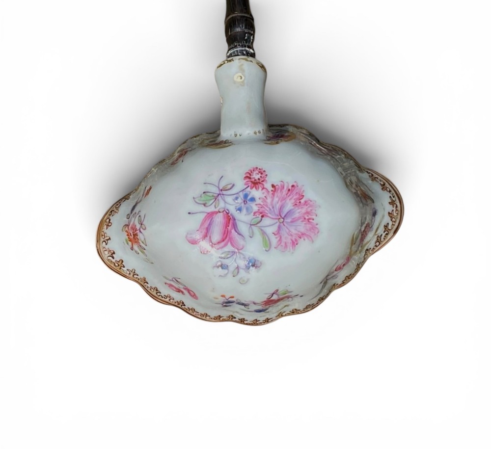 An 18th-century Chinese export famille rose porcelain ladle featuring a lobed white bowl painted with pink floral motifs and fitted with a dark turned handle. View IV