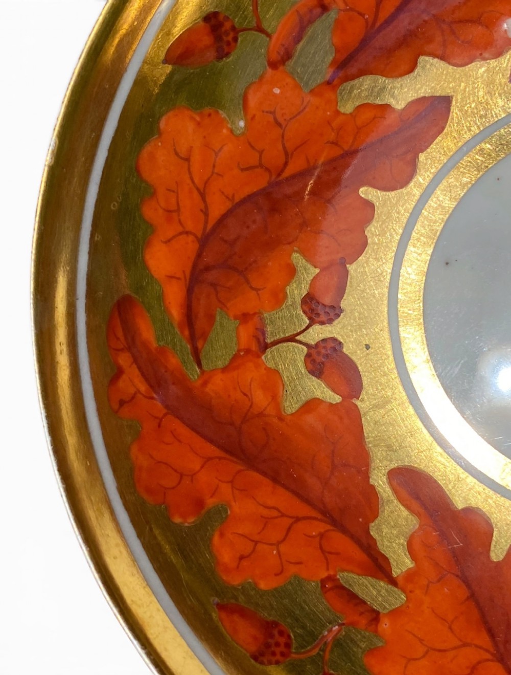 A Regency period Derby porcelain trio featuring two cups and a matching saucer decorated with red oak leaves and heavy gilding. View XIII