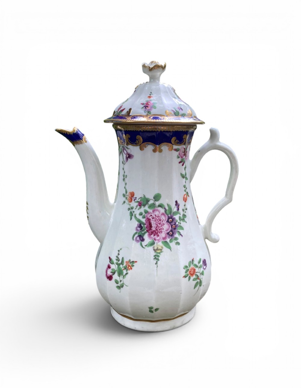 An 18th-century Worcester soft-paste porcelain coffee pot with a cobalt blue rim, hand-painted floral sprays, gilt detailing, and a matching lid with a flower finial.