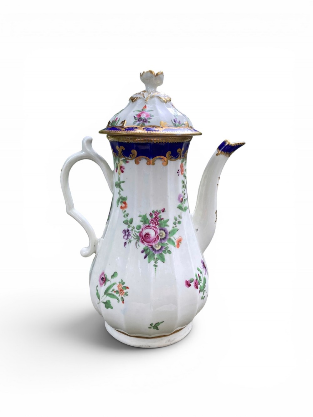 An 18th-century Worcester soft-paste porcelain coffee pot with a cobalt blue rim, hand-painted floral sprays, gilt detailing, and a matching lid with a flower finial. View V