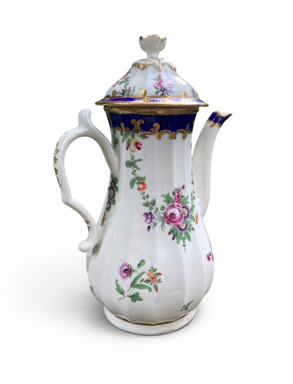 An 18th-century Worcester soft-paste porcelain coffee pot with a cobalt blue rim, hand-painted floral sprays, gilt detailing, and a matching lid with a flower finial. View VII