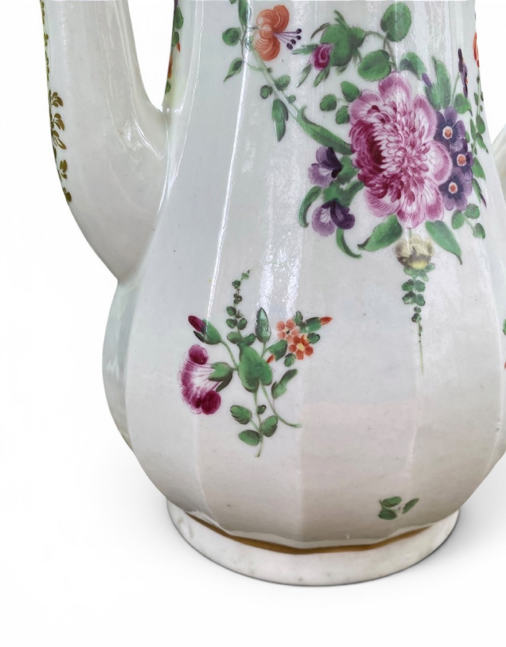 An 18th-century Worcester soft-paste porcelain coffee pot with a cobalt blue rim, hand-painted floral sprays, gilt detailing, and a matching lid with a flower finial. View X