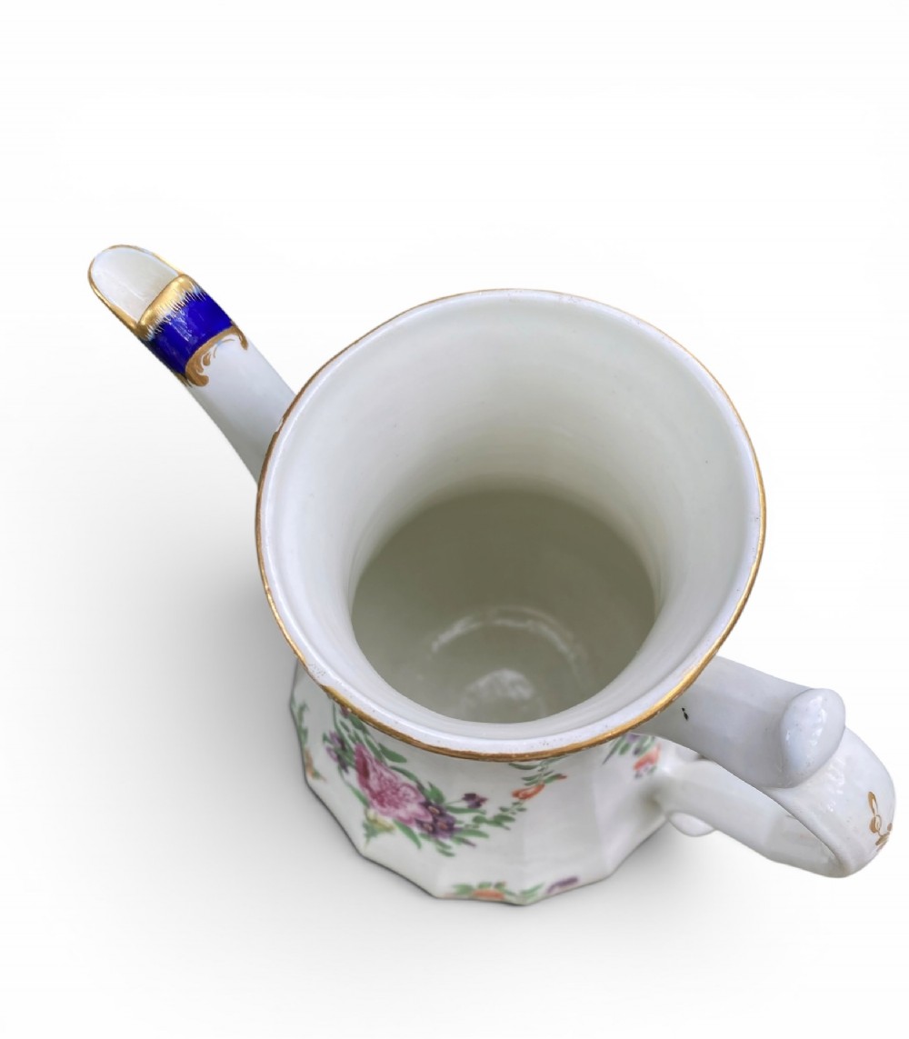 An 18th-century Worcester soft-paste porcelain coffee pot with a cobalt blue rim, hand-painted floral sprays, gilt detailing, and a matching lid with a flower finial. View XII
