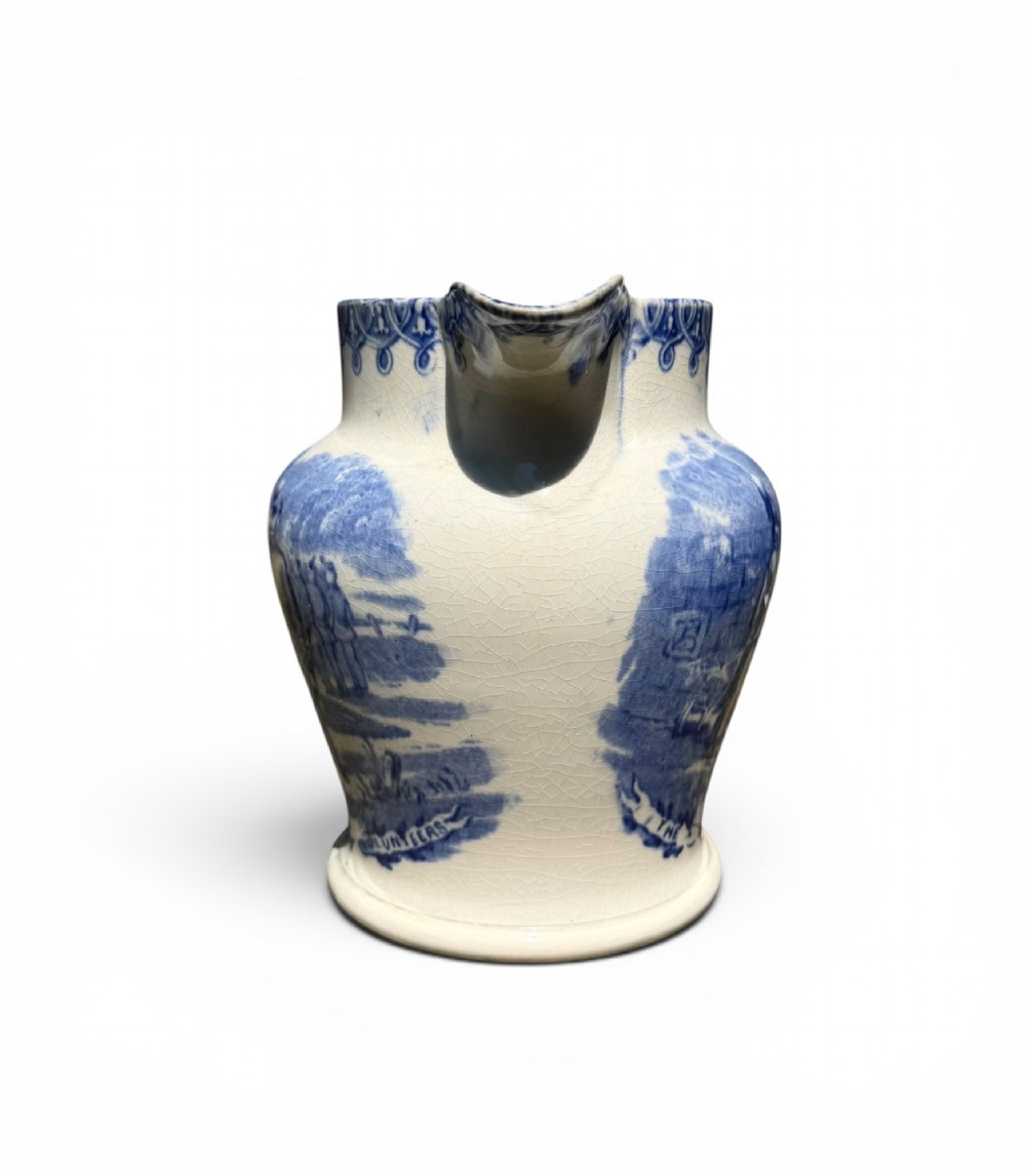 A cream earthenware jug featuring cobalt blue transferware depicting military figures labeled The British Volunteers. View II
