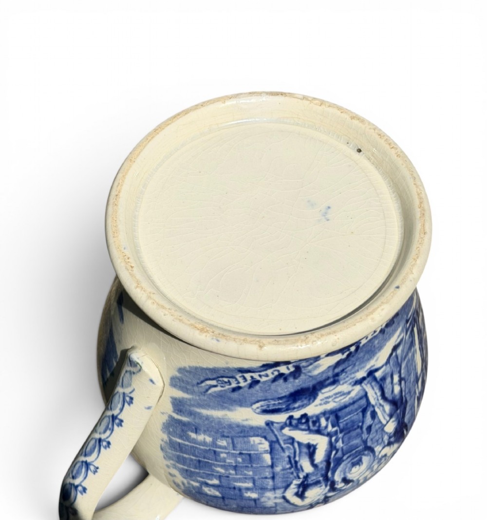 A cream earthenware jug featuring cobalt blue transferware depicting military figures labeled The British Volunteers. View VIII