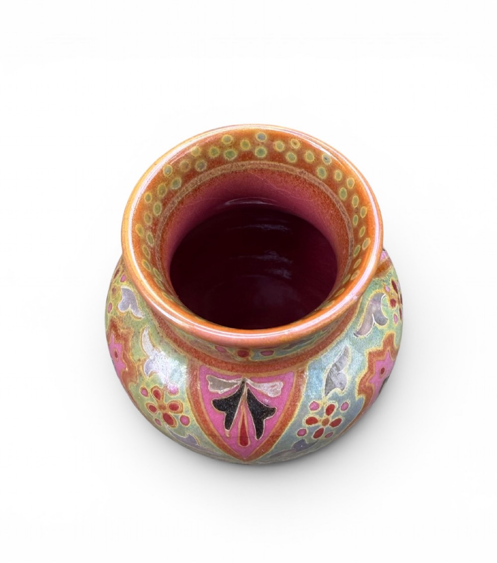 A baluster-shaped ceramic vase featuring intricate Persian-style geometric star medallions and foliate patterns in pink, olive green, and yellow lustre glazes. View V