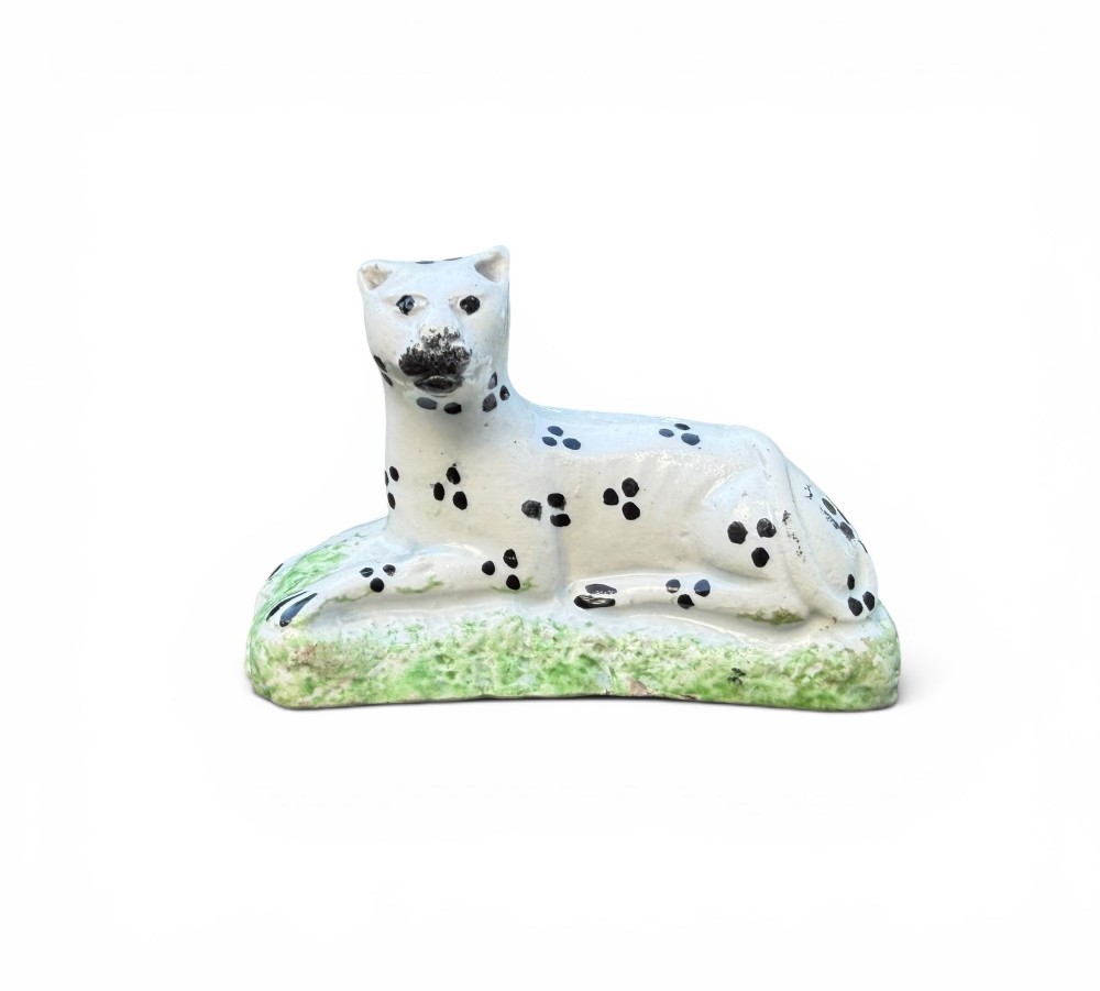 A pair of small antique white pearlware figures of recumbent spotted leopards resting on moulded green bases. View III