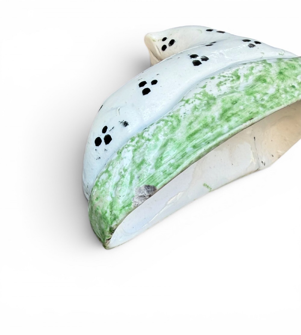 A pair of small antique white pearlware figures of recumbent spotted leopards resting on moulded green bases. View VII