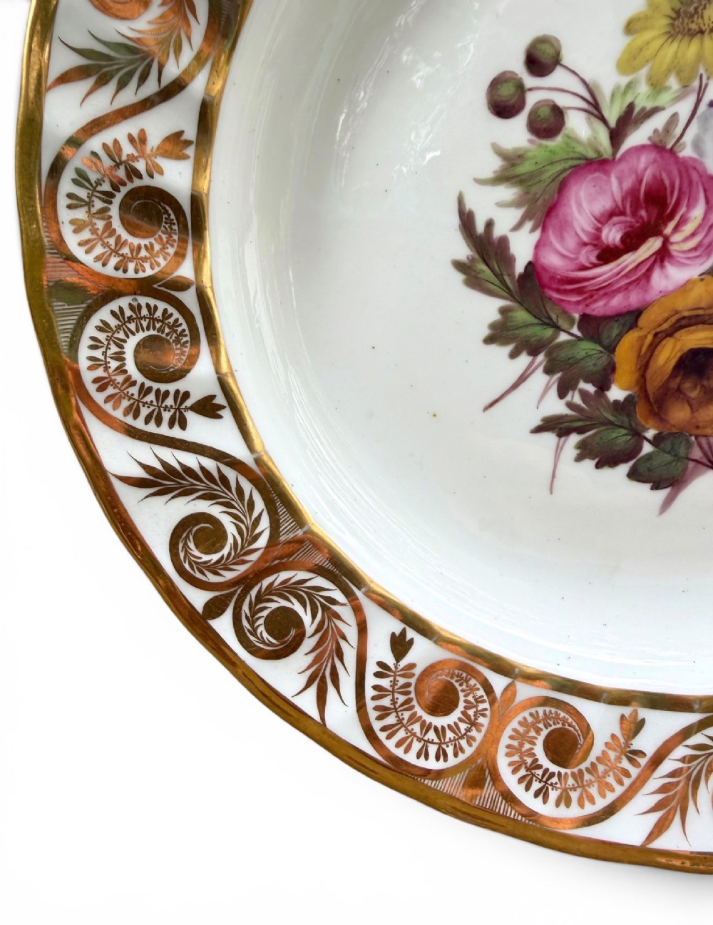 A circular white porcelain dish featuring a hand-painted floral centrepiece framed by a gilded scrollwork rim. View III