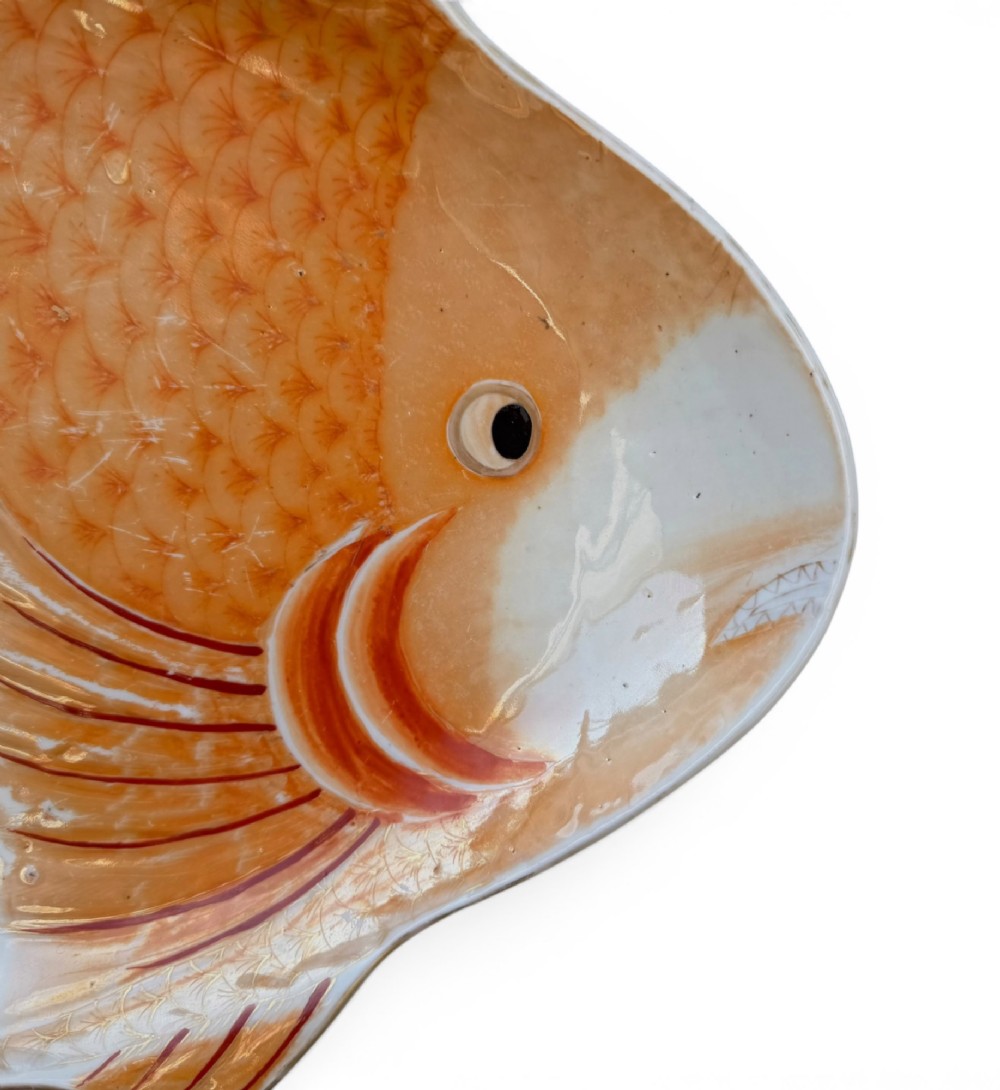 An antique Japanese Arita porcelain dish shaped like a fish with detailed orange hand-painted scales and fins. View II