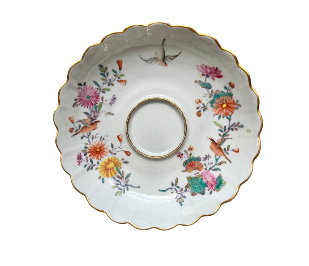A Chinese export famille rose porcelain twin-handled cup and scalloped stand decorated with hand-painted floral motifs, birds, and gilt edges. View II