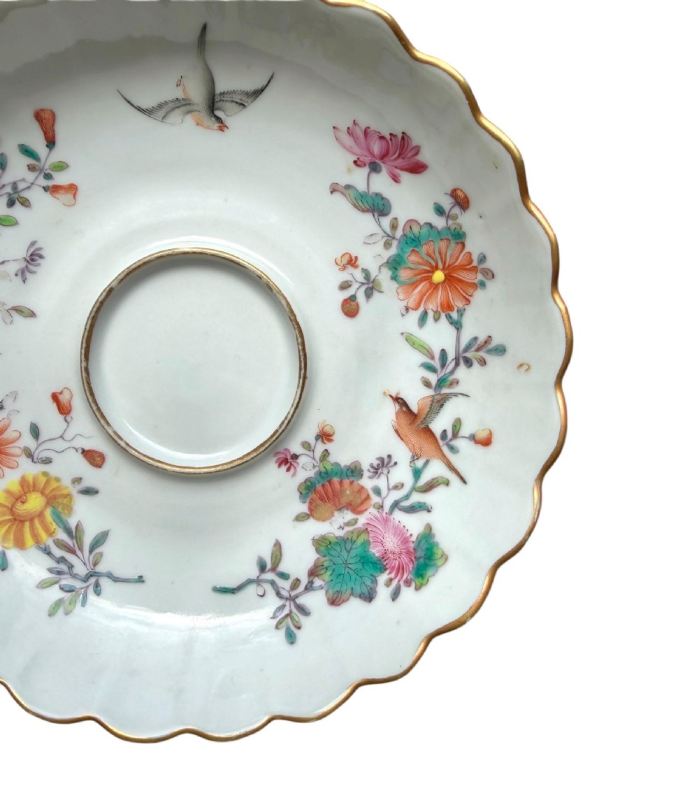 A Chinese export famille rose porcelain twin-handled cup and scalloped stand decorated with hand-painted floral motifs, birds, and gilt edges. View III