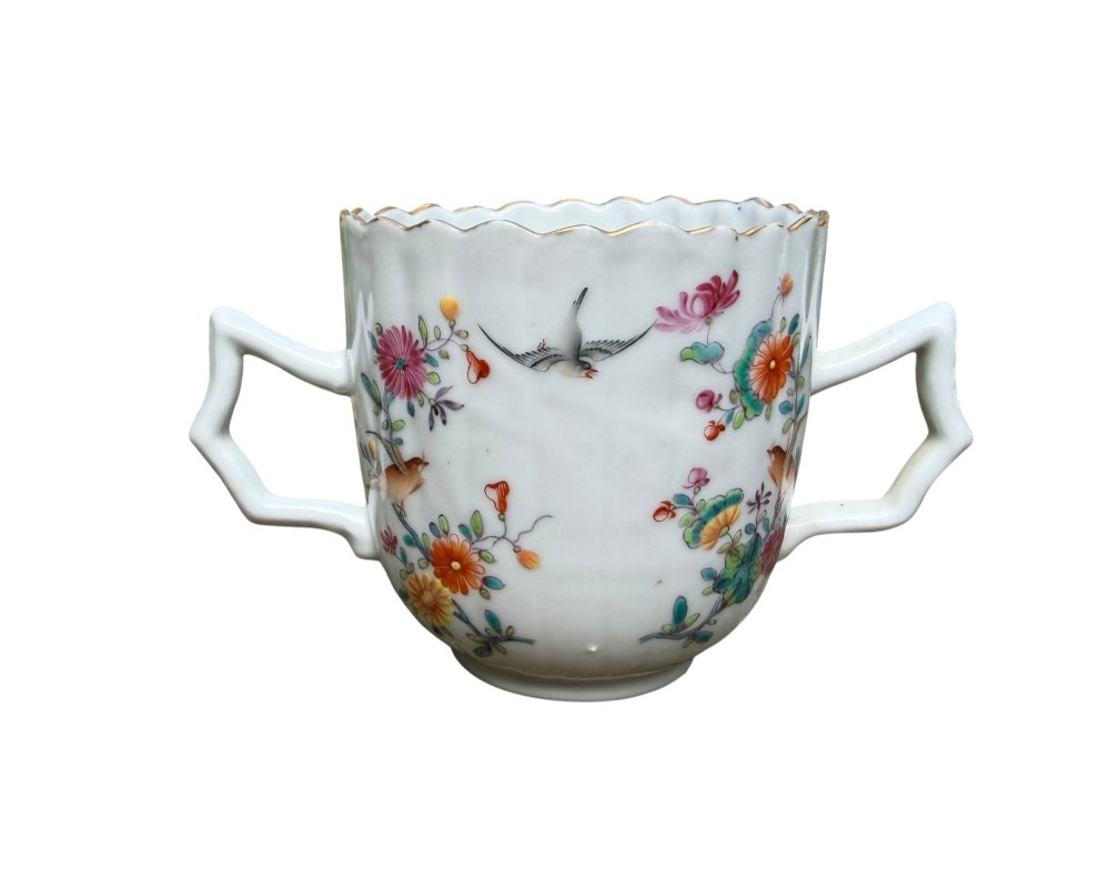 A Chinese export famille rose porcelain twin-handled cup and scalloped stand decorated with hand-painted floral motifs, birds, and gilt edges. View XI