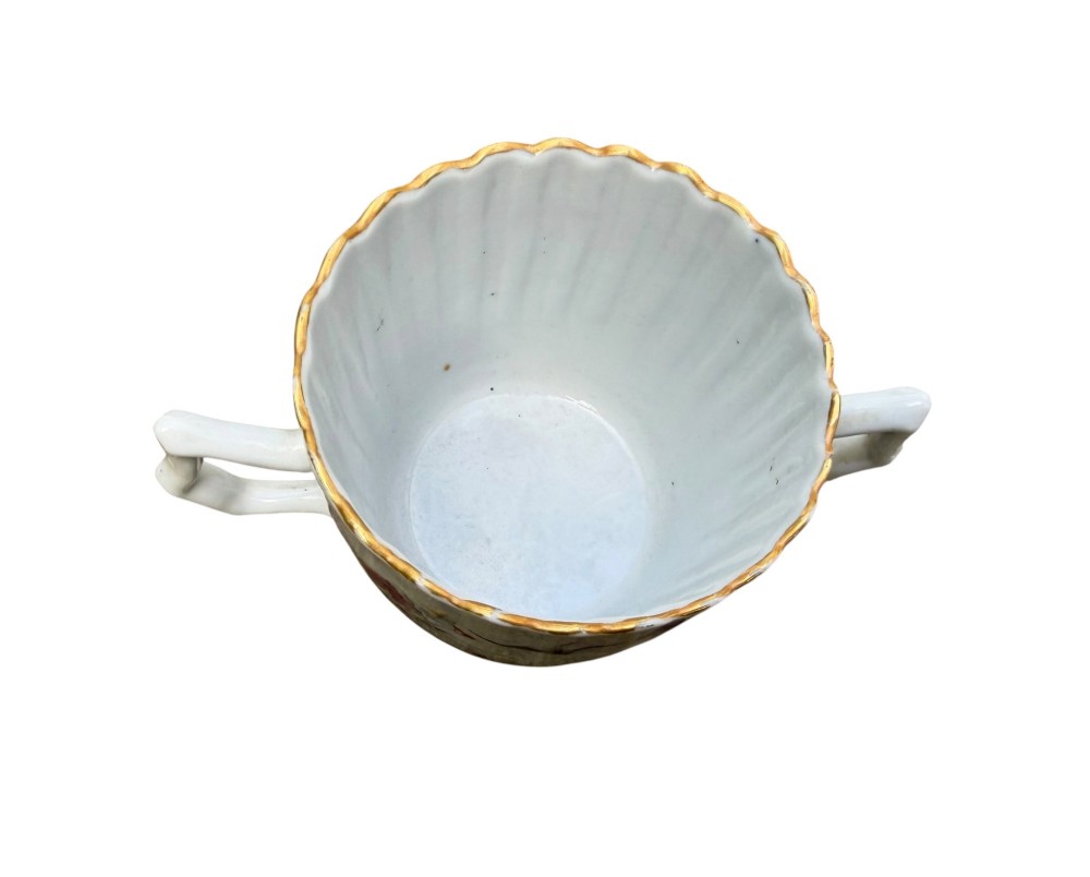 A Chinese export famille rose porcelain twin-handled cup and scalloped stand decorated with hand-painted floral motifs, birds, and gilt edges. View XIII